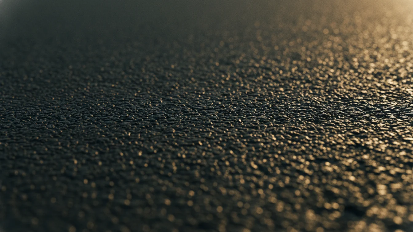 Surface de bitume frais en lumière dorée rasante
